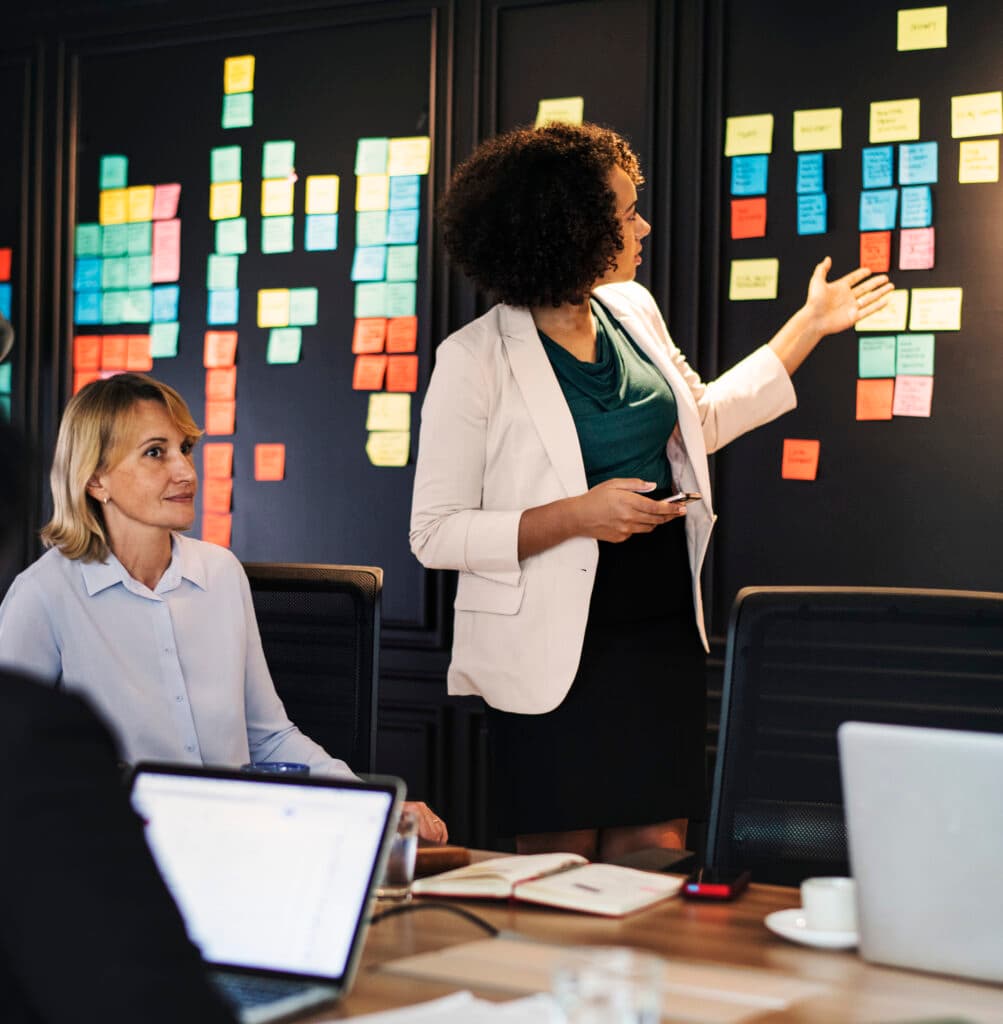 Colleagues planning work at a wall of notes